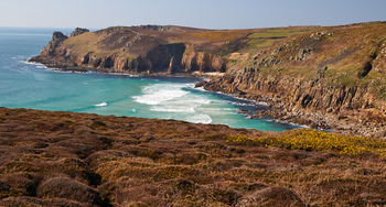 Landsend cliffs This landscape photograph shows the Landsend cliffs on the coast of Cornwall in the United Kingdom. Taken in the early afternoon during the spring season, the image captures the rugged natural beauty of the Cornish coastline, with dramatic cliffs rising sharply from the turquoise waters of the Atlantic Ocean. The foreground features brown and green vegetation typical of springtime coastal nature, while the background highlights the impressive rocky formations and gentle slopes of the cliffs. The composition showcases the raw texture and geological features that define this iconic part of Cornwall’s coast.